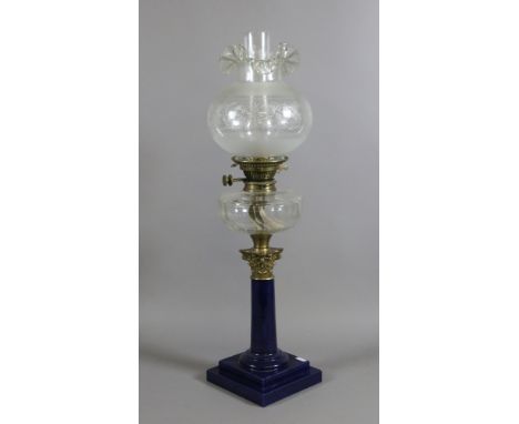 A large Victorian oil lamp with blue enamel column base, faceted clear glass font and etched glass shade and chimney.