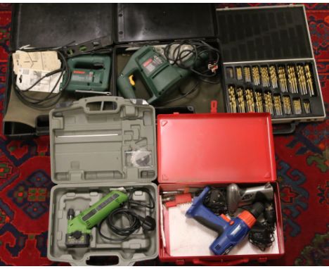 A collection of boxed electric power tools including Bosch, along with a tin of assorted drill bits.