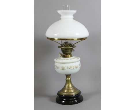 A Victorian brass based oil lamp with opaque hand decorated glass font and milk glass shade and chimney.