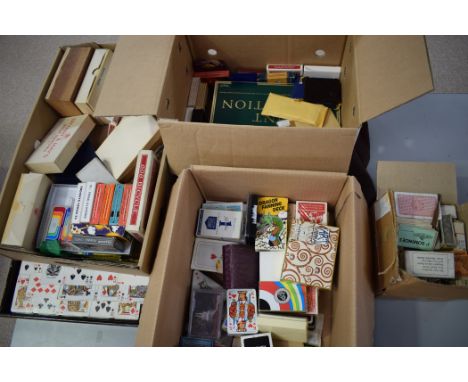 A large quantity of playing cards of all sizes and designs and a tower of playing cards.