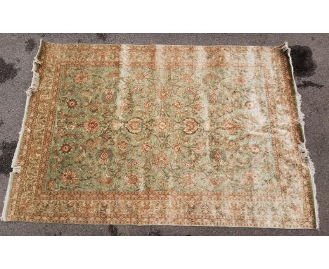 A hand woven silk Persian Nain rug, with light green ground designed with Shah Abbas floral palmettes motifs and fringed ends