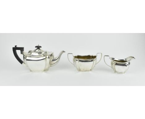 A late Edwardian silver three piece tea set, Birmingham 1910, comprising a teapot with ebony handle and finial to lid, a twin