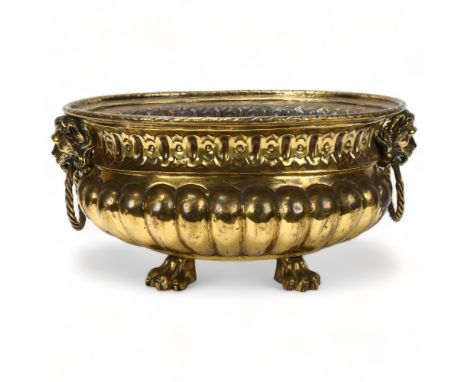 A 19th century oval brass jardiniere, with cast lion mask ring handles and lion paw feet, length 44cm excluding handlesGood o