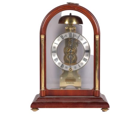A modern Hermle mahogany-cased dome-top mantel clock with brass columns, movement striking on a bell, case height 29cmVisuall