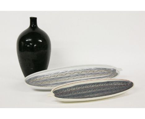 A Poole Studio vase, with a gloss black glaze, impressed seal, 25.55cm high and two cucumber dishes, 32.5 and 4241.5cm long (