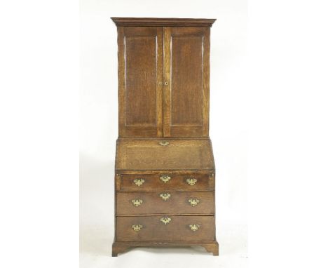 A George lll oak bureau cabinet,with a pair of panel doors, enclosing adjustable shelves and drawers above a fall front and t