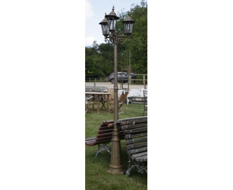 A three light cast metal garden lamp of streetlight form, on fluted column support, 212cm tall