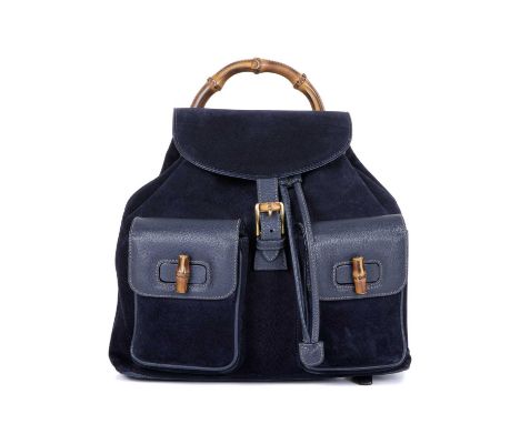 Gucci, a large Bamboo backpack, designed with a navy blue suede exterior with grained leather trim, featuring a curved bamboo