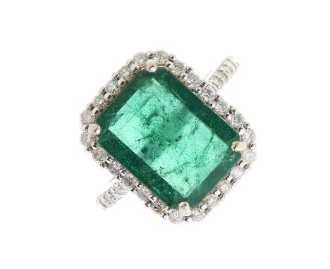An 18ct gold emerald and brilliant-cut diamond cluster ring, with similarly-cut diamond line shoulders, emerald estimated wei