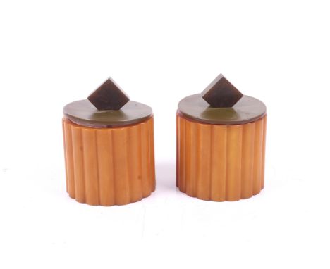 A pair of Bakelite Art Deco jars and covers. Having ribbed orange exteriors and brown lids, H10cm