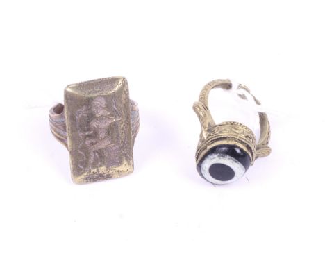 Two antique style rings. The first possibly Phoenician, with a black and white stone, the second possible Bactrian, in the fo