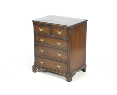 A Victorian walnut chest of drawers. Two short over three long graduated drawers, all with brass handles, raised on bracket s