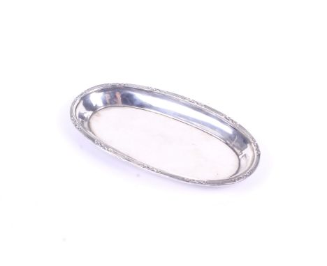 A small oval Mappin & Webb silver ring dish. The everted lip rim with a reeded border interspersed with sprigs of leaves. Hal