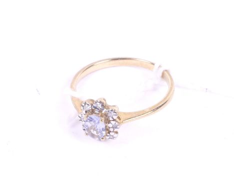 A modern 9ct white and yellow gold, tanzanite and diamond oval flower-head cluster ring. Centred with a small oval pale-blue 