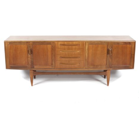 A mid-century G plan sideboard. The four central graduated drawers flanked by panelled cupboards, each containing a single ad
