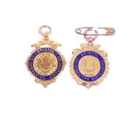 Two 9ct gold Bristol co-operative festival medals. With blue enamel decoration, gross weight 17.8g.