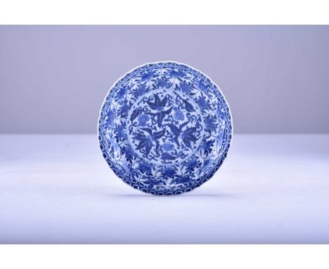 A Chinese blue and white moulded dish, KangxiOf slightly barbed form with moulded cavetto, decorated with peony flowers and f