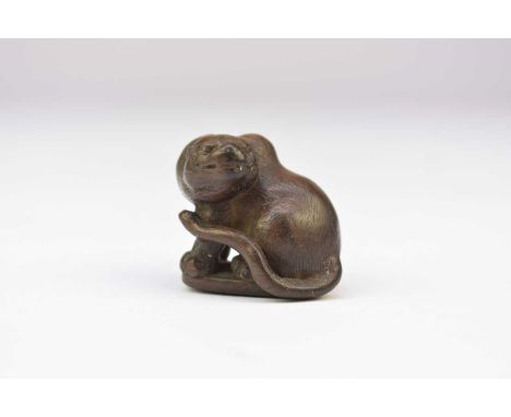 A Japanese wood netsuke of a tiger, Meiji eraModelled seated, its head turned back to the left, its tail curled forward to th