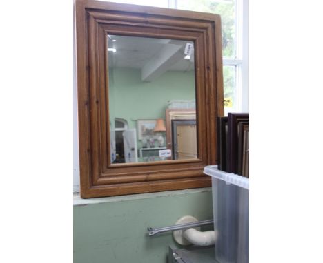 A RECTANGULAR BEVEL PLATE WALL MIRROR in moulded pine frame 