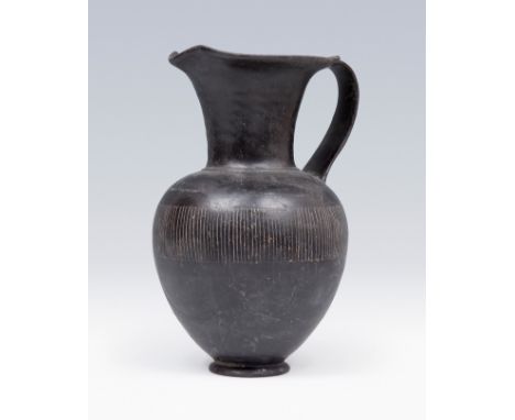 Etruscan Oinochoe, 6th century BC. Black glazed ceramic or bucchero. Measures: 24 x 15 x 14 cm. The oinochoe is a wine jug us