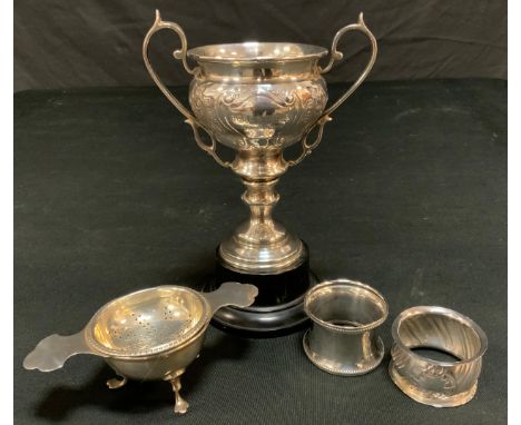 An 1930s silver twin handled trophy cup, Sheffield1937, engraved Dore & Totley Golf Club, J C Howard;  a silver tea strainer 