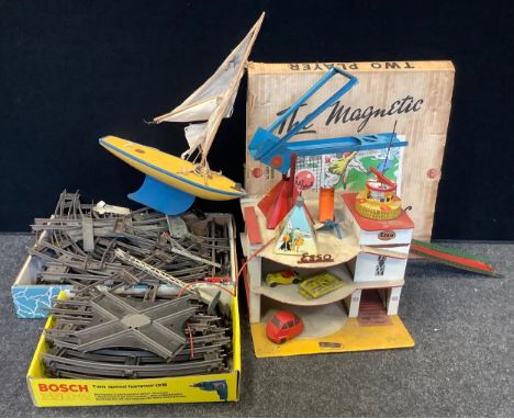 A Star Yachts single mast pond yacht, yellow and blue hull;  Gee Bee toys ESSO garage;  tinplate Merit Toys loading hopper;  