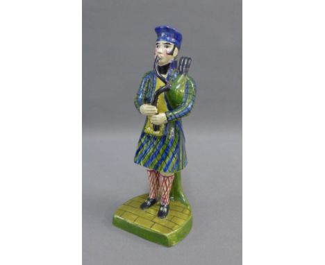 Early 19th century Portobello pottery figure of a Bagpiper, modelled standing wearing a tartan jacket, kilt and blue tam o'sh