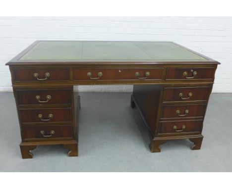 Mahogany veneered desk with a green leather skivver and arrangement of nine drawers, on bracket feet, 81 x 152 x 92cm