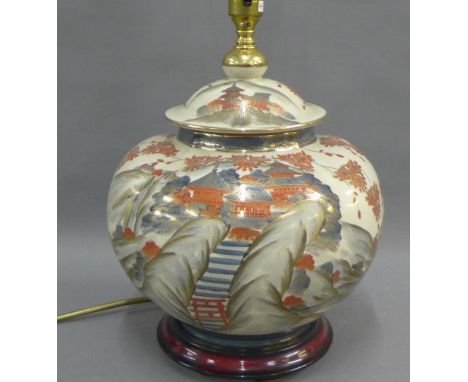 Satsuma table lamp base of lobed form and painted with pagodas and a blossom landscape, with signature seal mark, on a wooden