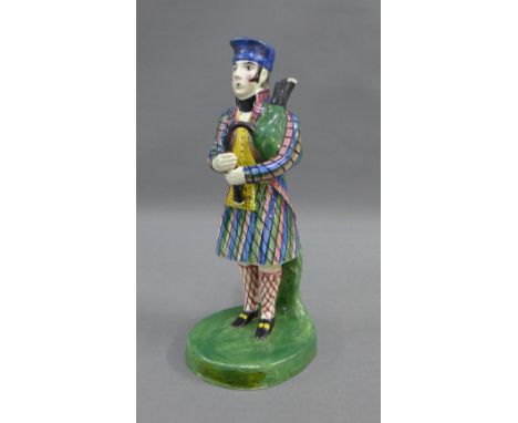 Early 19th century Portobello pottery figure of a Bagpiper, modelled standing in his tartan jacket and kilt and wearing a blu