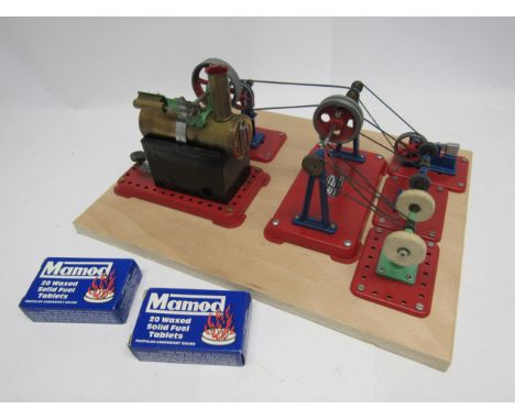 A Mamod live steam stationary engine with horizontal brass boiler, mounted on a wooden board with various line shaft accessor