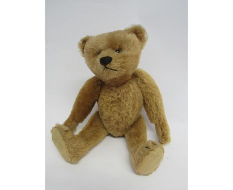 Attributed to Steiff- A mid 20th Century straw filled teddy bear, the reddish blonde mohair bear with black boot button eyes,