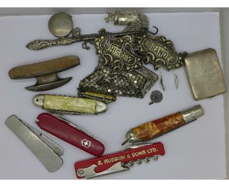 A silver nail buff, a misers purse, one other purse, two wine labels, a button hook, a matchbook case and six pocket knives