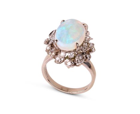 An 18k white gold opal and diamond oval cluster ring, the central oval cabochon opal approximately 16mm x 10.7mm, high openwo
