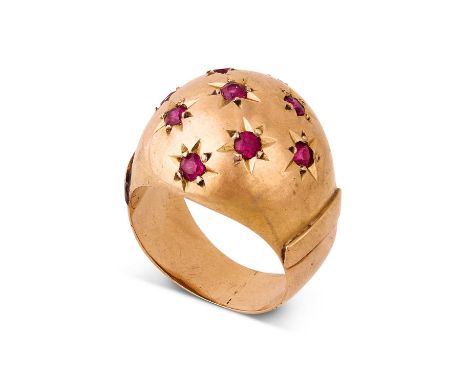 A Continental 18k yellow gold and ruby bombe ring, set with nine round cut rubies in star settings, to a plain polished shank