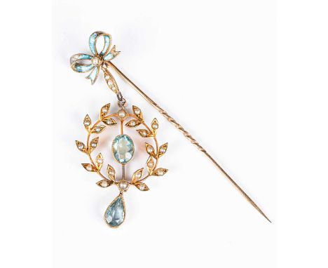 An Edwardian 9ct yellow gold aquamarine and seed pearl pendant stick pin, the blue enamel bow terminal suspending a circular 