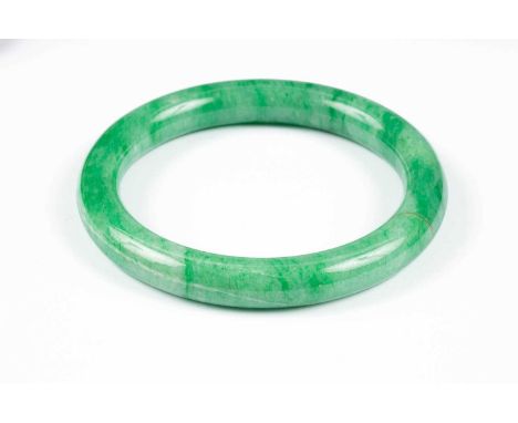 A green jade bangle, 8.8cm outer diameter, internal width approximately 6.7cm, in fitted case by Yamanaka &amp; Co, 127 New B