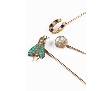 Three yellow metal gem set stick pins, including a turquoise and seed pearl fly, a lapis lazuli and seed pearl horseshoe, and