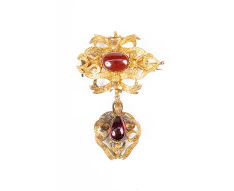 A Victorian garnet brooch, centred by an oval cabochon garnet in an engraved yellow metal surround and suspending a removable