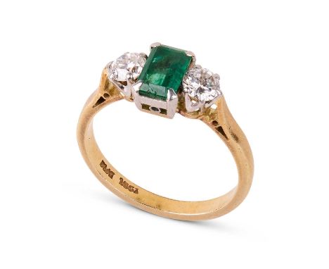 An 18ct yellow gold, emerald and diamond three-stone ring, the rectangular cut emerald approximately 7mm x 4.5mm, flanked by 