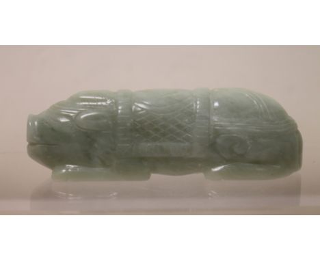 Chinese light green jade figure of a recumbent pig in the Han Dynasty style, probably 20th century. 11.5cm long.