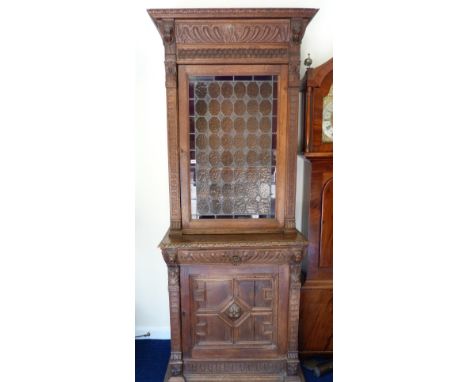 Victorian oak display cabinet, profusely carved with feathers, scrolls and overlapping scales, carved busts and lion & ring m