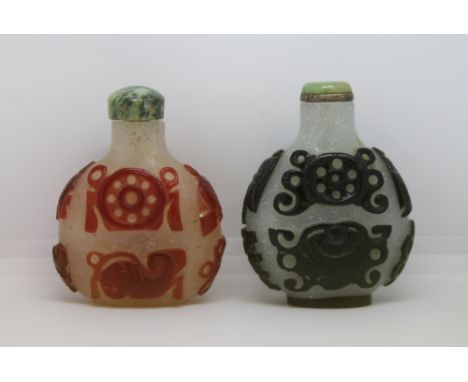 19th century Chinese single red overlay snuff bottle carved with Buddhist symbols, snow ground and mottled jade stopper, 6.5c