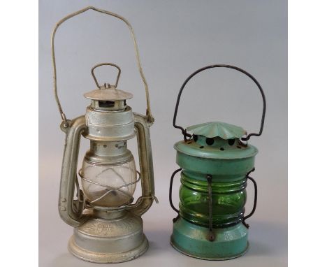 Two vintage tin and glass single oil burners, one marked 'Made in China'. (2) (B.P. 21% + VAT)