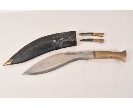 A Middle Eastern Kukri Knife, having brass handle, decorative design to either side of the blade, with inlaid decoration, com