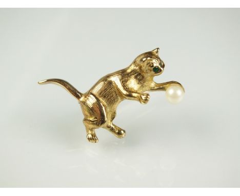 A 9ct gold pussycat brooch, naturalistically modelled with green stone set eyes playing with a cultured pearl 'wool' ball, 34