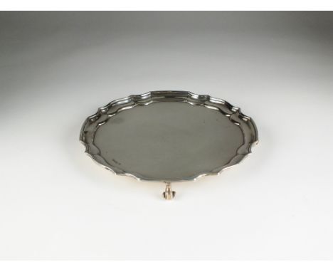 A silver waiter, James Deakin & Sons, Sheffield 1916, of circular form with pie crust rim, raised on four scroll feet and eng