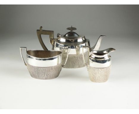 An Edwardian three piece silver tea service, James Dixon & Sons Ltd, Sheffield 1901, each piece of oval half reeded form, com