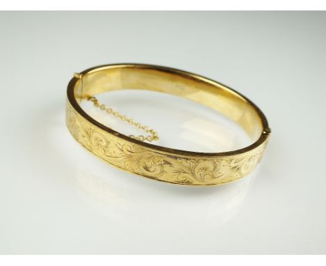 A 9ct gold hinged bangle, with engraved bright cut decoration, weight 16.7g