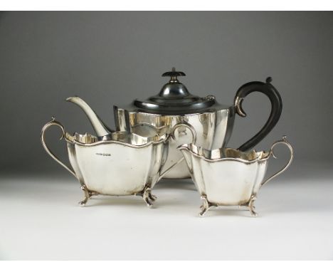 A three piece silver tea service, Harrison Fisher & Co, Sheffield 1931, each piece of shaped oval from with inverted corners 